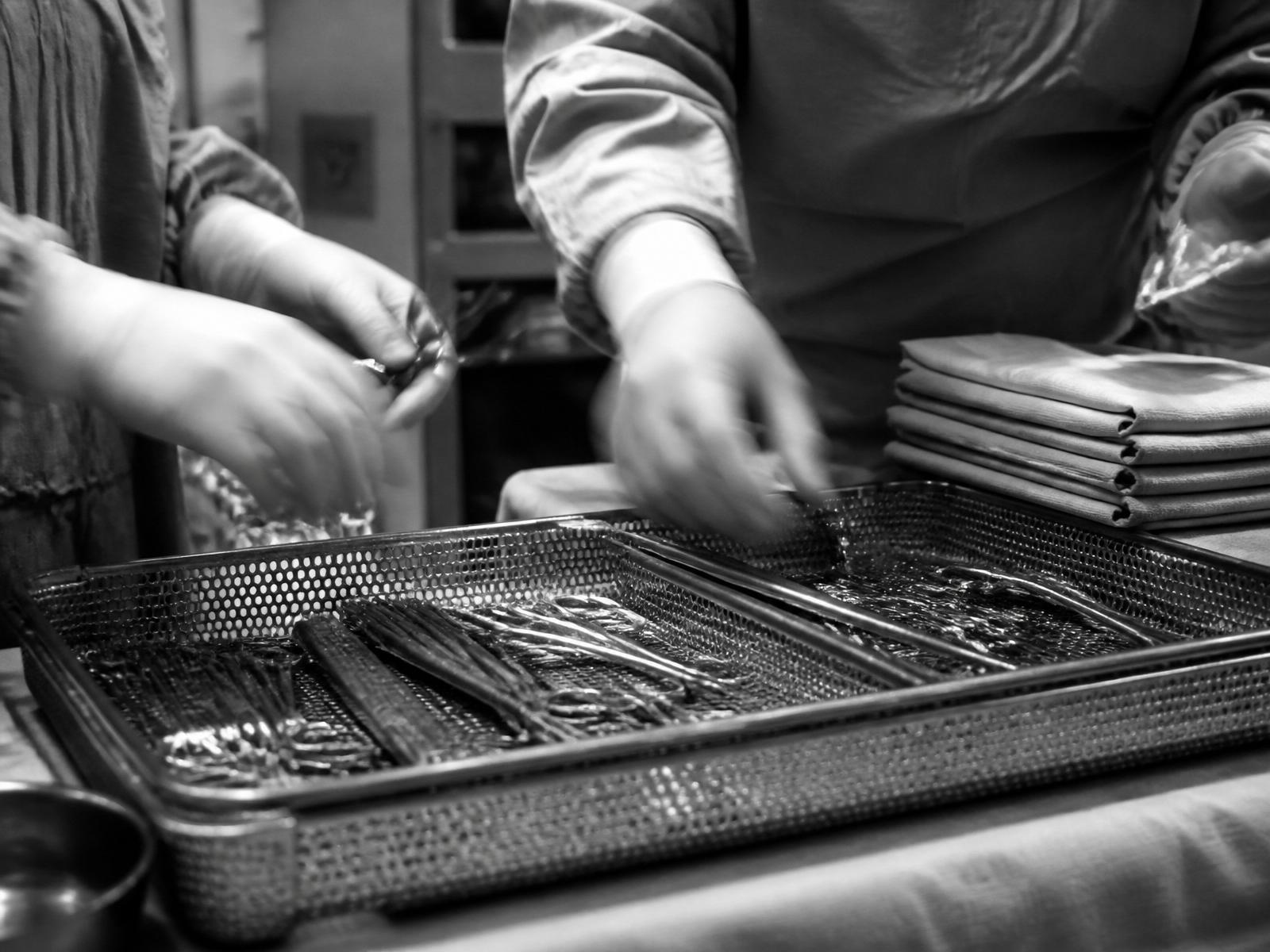 Scrub team setting the sterile instrument tray during turnover